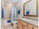 Bathroom with a shower-tub combination, tile surround, and a vanity with a framed mirror at 3546 Flamingo Blvd, Hernando Beach, FL 34607