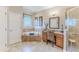 Bathroom featuring a bathtub, tiled shower, vanity area with chair, and neutral-colored tile flooring at 3546 Flamingo Blvd, Hernando Beach, FL 34607