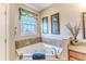 Bathroom featuring a corner bathtub with tile surround and decorative artwork displayed on the wall at 3546 Flamingo Blvd, Hernando Beach, FL 34607