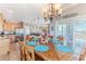 A dining room showcasing a wooden table, chandelier, and open access to the kitchen and views of the outdoor deck at 3546 Flamingo Blvd, Hernando Beach, FL 34607