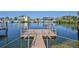 Inviting wooden dock with railings and ladder leading into a serene canal offering direct water access at 3546 Flamingo Blvd, Hernando Beach, FL 34607
