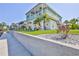 Inviting two-story coastal home with a lovely balcony, vibrant green lawn and meticulous landscaping at 3546 Flamingo Blvd, Hernando Beach, FL 34607