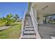 Exterior stairs leading to a charming waterfront home, surrounded by tropical plants and lush landscaping at 3546 Flamingo Blvd, Hernando Beach, FL 34607