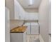 Functional laundry room with white cabinets, wood countertop, and modern washer and dryer units at 3546 Flamingo Blvd, Hernando Beach, FL 34607