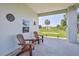 Inviting outdoor seating area with comfortable Adirondack chairs, side table, and view of the lawn at 3546 Flamingo Blvd, Hernando Beach, FL 34607