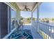 Relaxing patio overlooking the waterfront featuring comfortable seating, ceiling fan, and vibrant outdoor rug at 3546 Flamingo Blvd, Hernando Beach, FL 34607