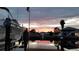 Scenic waterfront view from the dock with a boat, palm trees, and a tranquil sunset sky at 3546 Flamingo Blvd, Hernando Beach, FL 34607