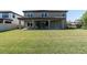 Expansive backyard with lush green lawn and covered patio, perfect for outdoor entertaining at 3767 Dragonfly Trl, Odessa, FL 33556