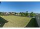 Lush backyard view with green grass, lake, and manicured landscaping at 3767 Dragonfly Trl, Odessa, FL 33556