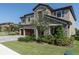 Two-story home featuring a three car garage, stone facade and professionally landscaped front yard at 3767 Dragonfly Trl, Odessa, FL 33556