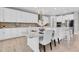 Bright, modern kitchen with white cabinetry, marble countertops, a decorative backsplash, and seating at the island at 3767 Dragonfly Trl, Odessa, FL 33556