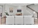 Spacious living area features a cozy seating arrangement, stylish decor, and stairway to second level at 3767 Dragonfly Trl, Odessa, FL 33556