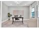Bright home office featuring neutral walls, a dark desk, patterned rug, and natural light from a large window at 3767 Dragonfly Trl, Odessa, FL 33556