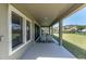 Long covered patio with comfortable seating and a view of the lush, green backyard at 3767 Dragonfly Trl, Odessa, FL 33556