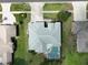 Aerial view of a home with a screened pool, complemented by a driveway and manicured lawns at 4048 St Ives Blvd, Spring Hill, FL 34609
