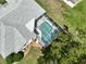 Aerial view of the home highlighting the screened pool and well-manicured landscaping at 4048 St Ives Blvd, Spring Hill, FL 34609