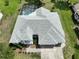 An aerial view of a single-story home with a well-maintained roof and a spacious driveway, surrounded by green lawns at 4048 St Ives Blvd, Spring Hill, FL 34609