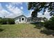 Expansive backyard featuring a screened-in pool, lush lawn, and mature trees under a sunny sky at 4048 St Ives Blvd, Spring Hill, FL 34609