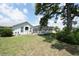 A spacious backyard with a screened-in pool, green lawn, and large shady tree, creating a relaxing outdoor space at 4048 St Ives Blvd, Spring Hill, FL 34609