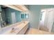Bright bathroom featuring a double sink vanity, tile floors, and stylish striped wallpaper at 4048 St Ives Blvd, Spring Hill, FL 34609