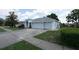 A well-maintained home featuring a three-car garage, manicured landscaping, and a serene residential setting at 4048 St Ives Blvd, Spring Hill, FL 34609