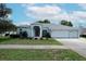 Charming single-story home featuring a well-manicured lawn and a three car garage at 4048 St Ives Blvd, Spring Hill, FL 34609