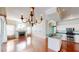 Spacious room showcasing fireplace, hardwood floors, light walls with mural, and a modern kitchen at 4048 St Ives Blvd, Spring Hill, FL 34609