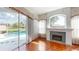 Living room featuring fireplace, large sliding glass doors to pool, and hardwood floors at 4048 St Ives Blvd, Spring Hill, FL 34609