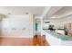Open-concept living room with hardwood floors, light walls with mural, and modern kitchen at 4048 St Ives Blvd, Spring Hill, FL 34609