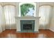 Bright living room with a fireplace, hardwood floors, and large windows overlooking lush greenery at 4048 St Ives Blvd, Spring Hill, FL 34609