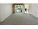 Bright living room features sliding glass doors to the pool area and neutral carpeting at 4048 St Ives Blvd, Spring Hill, FL 34609