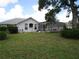 The backyard features a large well-maintained lawn and screened in pool enclosure at 4048 St Ives Blvd, Spring Hill, FL 34609