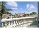 Balcony view showcasing neighborhood homes, palm trees, blue sky, and ocean at 4348 Harborpointe Dr, Port Richey, FL 34668