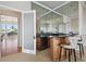 Entertaining bar area featuring sleek cabinetry, marble countertops, mirrored backsplash, and access to outdoor space at 4348 Harborpointe Dr, Port Richey, FL 34668