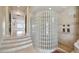 Tiled bathroom with glass brick shower enclosure, columns, and steps at 4348 Harborpointe Dr, Port Richey, FL 34668