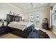 Bright bedroom boasts a black bed frame, wood floors, and balcony access at 4348 Harborpointe Dr, Port Richey, FL 34668