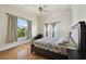 Bright bedroom with a ceiling fan, light-colored walls, and a large window offering a tropical view at 4348 Harborpointe Dr, Port Richey, FL 34668
