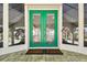 Close up view of the emerald green double door entryway with glass panels and bronze hardware at 4348 Harborpointe Dr, Port Richey, FL 34668