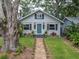 Charming home featuring a well-manicured lawn, vibrant landscaping, and a welcoming blue front door at 435 11Th N Ave, St Petersburg, FL 33701