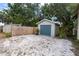 Detached one car garage with blue door and white gravel surround by privacy fence at 435 11Th N Ave, St Petersburg, FL 33701