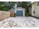 Detached one car garage with blue door and white gravel surround by privacy fence at 435 11Th N Ave, St Petersburg, FL 33701