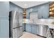 Well-lit kitchen featuring stainless steel appliances, light blue cabinets, and quartz countertops and backsplash at 435 11Th N Ave, St Petersburg, FL 33701