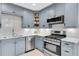 Updated kitchen boasts stainless steel appliances, light blue cabinets, and sleek quartz countertops and backsplash at 435 11Th N Ave, St Petersburg, FL 33701