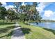 Scenic walking path along a serene lake with lush greenery and mature trees offers a tranquil outdoor experience at 435 11Th N Ave, St Petersburg, FL 33701