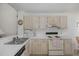 Galley kitchen featuring white cabinets, white countertops and a stainless steel sink at 4575 Whitton Way # 1132, New Port Richey, FL 34653
