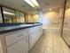 Bathroom features a double sink vanity, a toilet, and a shower with a seat and handrails at 4823 Ebbtide Ln # 105, Port Richey, FL 34668