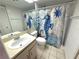 Bathroom with white tile and a decorated shower curtain at 4823 Ebbtide Ln # 105, Port Richey, FL 34668