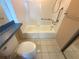 Bathroom interior featuring a shower, toilet, grab bars, tiled walls, and a solid surface sink and counter at 4823 Ebbtide Ln # 105, Port Richey, FL 34668