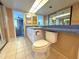 Bathroom view with a double sink, large mirror and tile floors and a partial view to the living room at 4823 Ebbtide Ln # 105, Port Richey, FL 34668