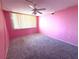 Bedroom featuring a ceiling fan, window, and neutral carpet at 4823 Ebbtide Ln # 105, Port Richey, FL 34668